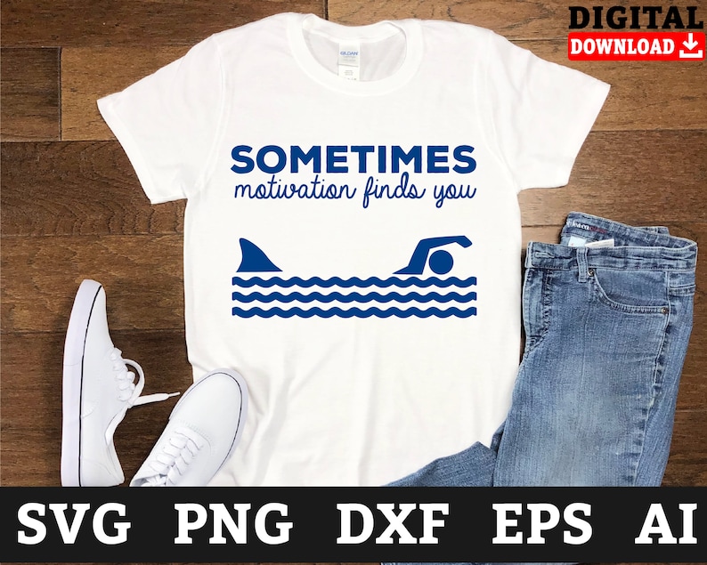 May include: White t-shirt with blue text that reads "Sometimes motivation finds you" and a blue silhouette of a shark fin and a swimmer in the water.