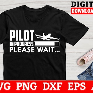 May include: Black t-shirt with white text that reads "Pilot in progress, please wait..." and a white airplane graphic.