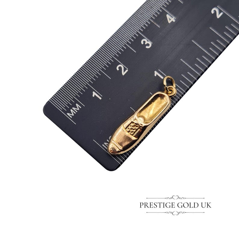 Profile shot of the 24mm hollow gold shoe charm, showing its curved and detailed loafer shape.