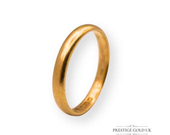 May include: A gold ring with a smooth, rounded band. The ring has a matte finish and is set against a white background. The ring is a classic design, suitable for everyday wear.