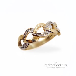 May include: A gold ring with a chain link design. The ring features alternating gold and silver-toned links, some of which are encrusted with small, sparkling stones. The ring is set against a white background.