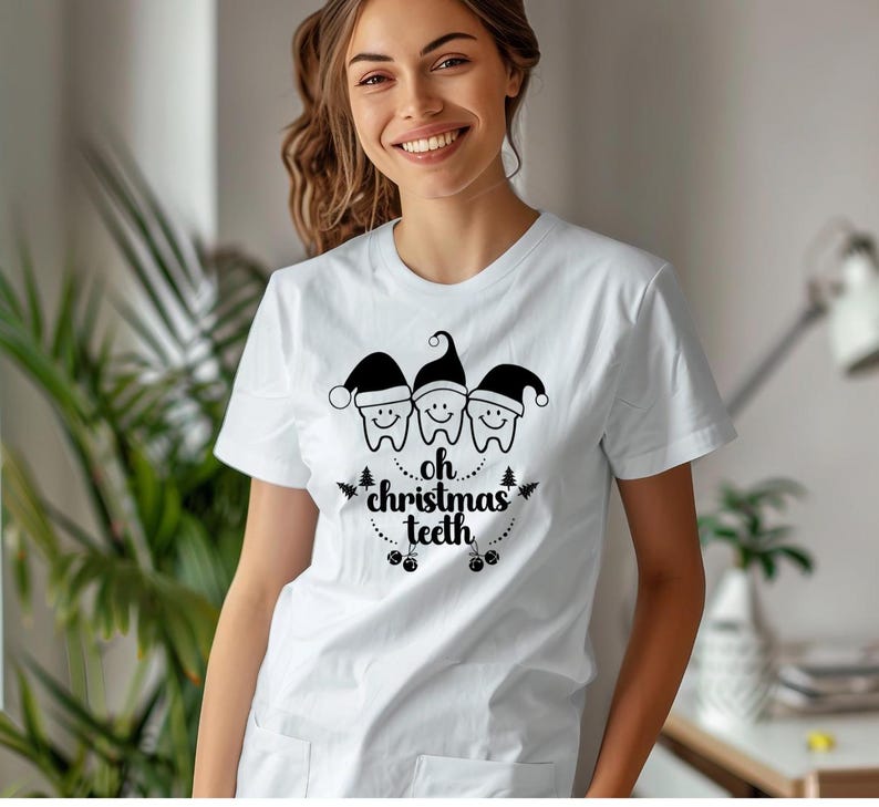 May include: White t-shirt featuring a graphic of three smiling teeth wearing Santa hats, with the text "oh christmas teeth" in a festive design. A fun and unique holiday-themed apparel item.