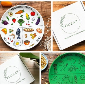 Puede incluir: Un juego de dos platos divididos para niños, uno blanco y otro verde, con ilustraciones de diferentes grupos de alimentos: frutas, verduras, proteínas y carbohidratos. Los platos son parte de un juego de la marca YouEat, que promueve hábitos alimenticios saludables.