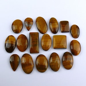 Peut inclure: Assortiment de 15 cabochons en œil de tigre de différentes formes et tailles. Les pierres sont un mélange de couleurs brunes et dorées avec un effet chatoyant.