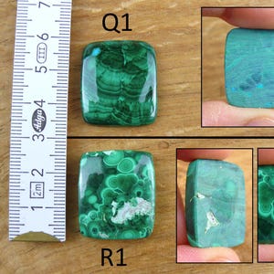 May include: Two malachite gemstones, labeled Q1 and R1, are displayed. The gemstones are rectangular with rounded corners. The malachite features a vibrant green color with swirling patterns. A ruler is placed next to the gemstones, showing measurements in centimeters.