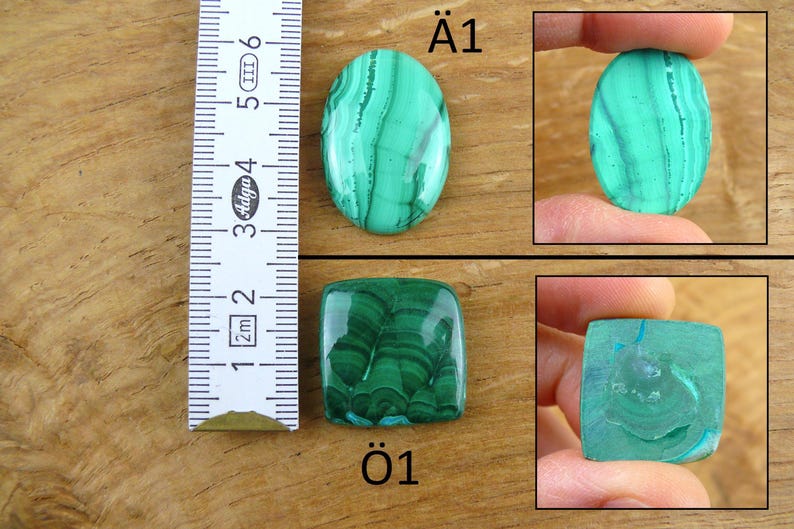 May include: The image showcases two malachite gemstones, one oval and one square, with a ruler for scale. The oval stone displays a vibrant green hue with intricate patterns. The square stone also exhibits a rich green color and unique veining.