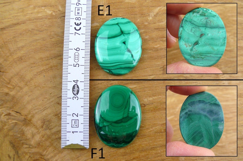 May include: Two oval-shaped malachite gemstones with a ruler for scale. The gemstones display a vibrant green color with darker green and black swirling patterns. The ruler shows measurements in centimeters.