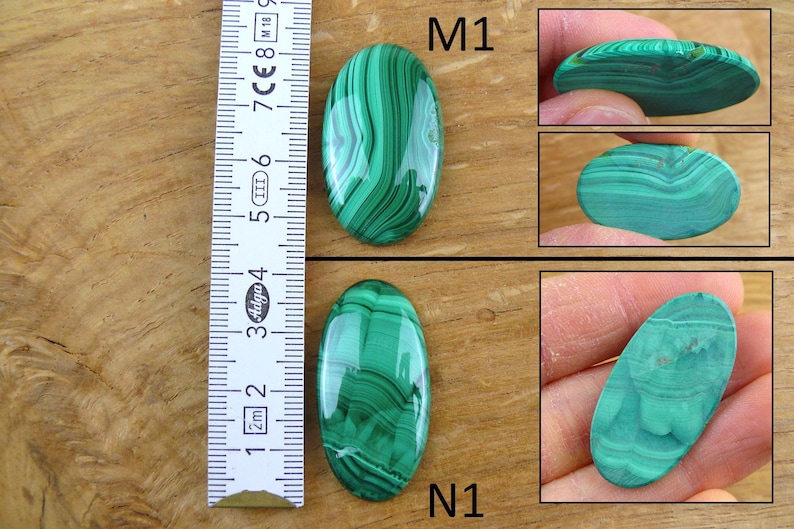 May include: Two oval-shaped malachite stones with green and dark green patterns. The stones are next to a ruler showing measurements in centimeters. Additional images show the stones from different angles, highlighting their polished surfaces.