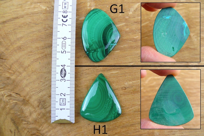 May include: Two polished malachite gemstones, one oval and one triangular, with a ruler for scale. The gemstones display a vibrant green color with intricate swirling patterns. The oval stone is approximately 2.5 inches long.
