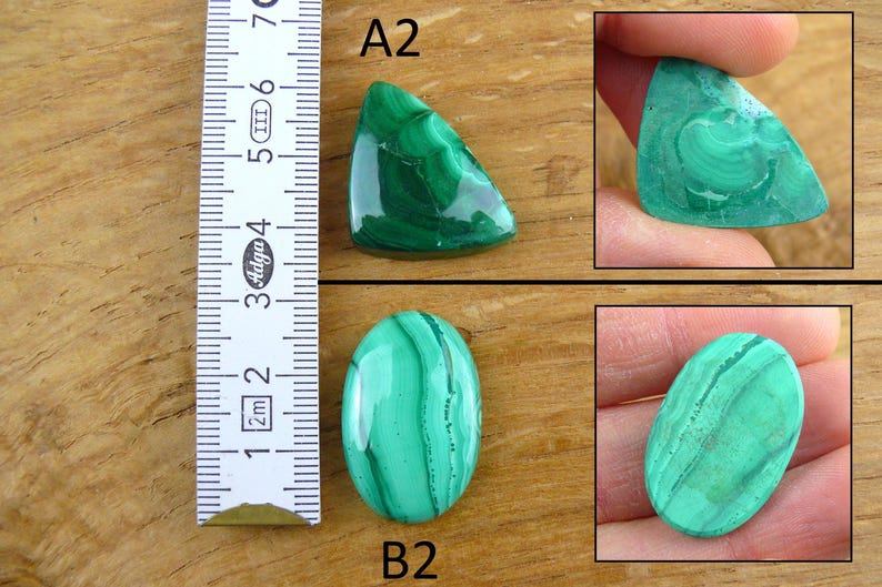 May include: A collection of polished malachite gemstones in various shapes. One is triangular, another oval, and a third is held in a hand. The malachite displays a vibrant green color with unique swirling patterns. A ruler is included for size reference.