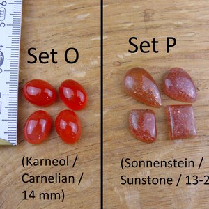 May include: Two sets of polished gemstones. Set O features four carnelian stones, each measuring 14 mm. Set P features five sunstone stones, ranging in size from 13 to 20 mm.