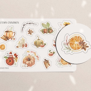 May include: A sheet of stickers with an autumn theme. The stickers feature illustrations of pumpkins, apples, cinnamon sticks, oranges, and other fall-themed imagery. The text "Autumn Cinnamon" and "Sticker Page" are printed on the sheet.