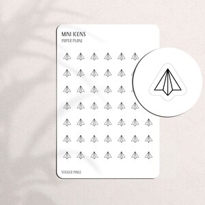 May include: White sticker sheet with black paper airplane icons. The sheet includes the text "MINI ICONS PAPER PLANE" and "STICKER PAGE". A circular sticker with a paper airplane design is also shown.