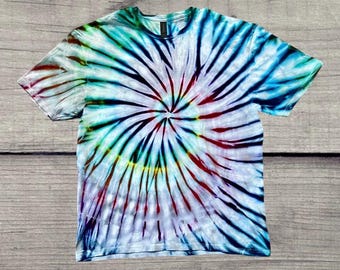 May include: A tie-dye t-shirt with a swirling pattern in shades of blue, green, red, and yellow.