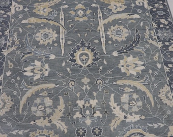 May include: A gray rug with a floral pattern. The rug has a border with a repeating pattern of small flowers.
