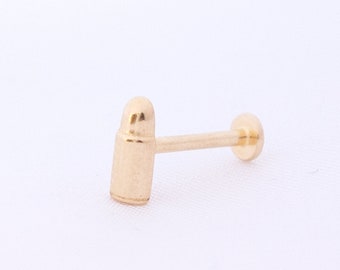 May include: A gold-colored bullet-shaped stud earring with a straight post.