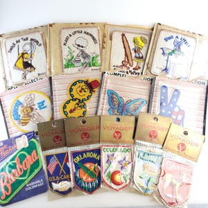 May include: A collection of vintage embroidered patches, featuring various designs and text. The patches include images of a bee, a butterfly, and state emblems. Some patches have text like "Smile at the World" and "Plant a Little Happiness."