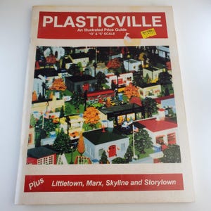 May include: A vintage "Plasticville" price guide with a red banner at the top. The cover features a colorful illustration of a miniature town with buildings, trees, and vehicles. The text reads "An Illustrated Price Guide" and "O & S Scale".