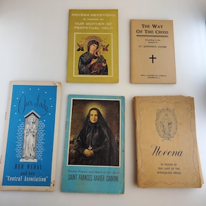 May include: A collection of five small, religious paperbacks. The books are all different colors and have various titles, including "Our Lady", "Novena Devotions in Honor of Our Mother of Perpetual Help", "The Way of the Cross", "Novena Prayers and Sketch of the Life of Saint Frances Xavier Cabrini", and "Novena in Honor of Our Lady of the Miraculous Medal".