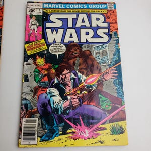 May include: A comic book cover featuring the characters Han Solo and Chewbacca from the Star Wars franchise. The cover is yellow with a red and pink laser beam shooting across the front. The text on the cover reads "Star Wars" and "All New! Man Sold and Chewbacca on a World the Law Forgot!"