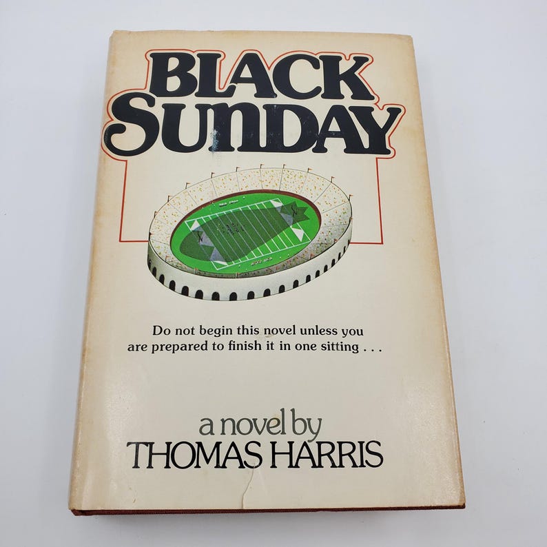 May include: A well-worn paperback book with the title "BLACK SUNDAY" by Thomas Harris. The cover shows a stadium illustration and the text: "Do not begin this novel unless you are prepared to finish it in one sitting..."