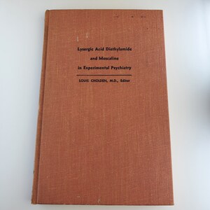 May include: A brown book with the title "Lysergic Acid Diethylamide and Mescaline in Experimental Psychiatry" by Louis Cholden, M.D., Editor.