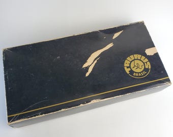 Puede incluir: Una caja negra con un borde dorado y un logotipo dorado que dice "Taurus Brasil".