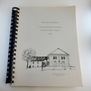 May include: A spiral-bound book with the title "Gravestone Inscriptions" and the subtitle "Church and Public Cemeteries in Fluvanna County, Virginia 1994." The cover features a black and white illustration of a church and a smaller building. The church is labeled "Lyles Baptist Church Established 1774."