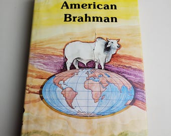 Puede incluir: Portada del libro "American Brahman" con un toro blanco sobre un globo terráqueo. El fondo es un efecto acuarela con tonos amarillos, morados y marrones. El título está en letras negras. Nombre del artista, Jules Bacot, en la parte inferior.