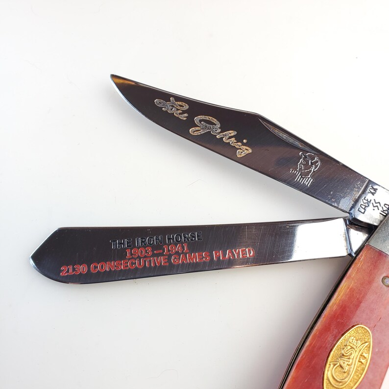 Puede incluir: Una navaja de bolsillo Case XX con mango rojo y dos hojas. Una hoja tiene la inscripci&oacute;n "Lou Gehrig" y un retrato. La otra hoja dice "The Iron Horse 1903-1941 2130 Consecutive Games Played" en rojo.
