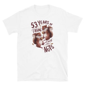 May include: White t-shirt with a brown squirrel illustration holding a nut. The text "53 years of driving each other nuts" is printed on the shirt.