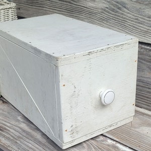 May include: White wooden box with a white knob. The box has a distressed finish and is made of wood.