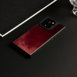 May include: A rectangular smartphone case featuring a deep red, cloud-like gradient pattern on the back panel. The case has a black frame and a raised black camera module with three circular lenses. The word HORYTOWN is printed in small white text.