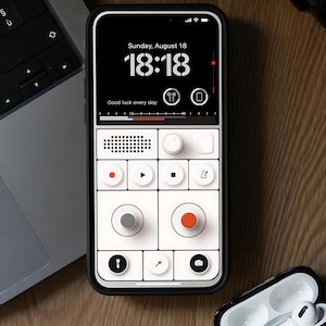 May include: A black smartphone with a white and black interface, displaying the time and the words "Good luck every day." The phone is next to a laptop and a pair of white earbuds in a black case. The brand name "MONZA" is visible.