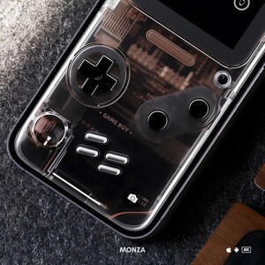 Pu&ograve; includere: Una custodia per telefono trasparente con un design Game Boy. La custodia presenta un pulsante nero a forma di croce, due pulsanti rotondi e una serie di pulsanti pi&ugrave; piccoli. Il testo "GAME BOY." &egrave; stampato sulla custodia.