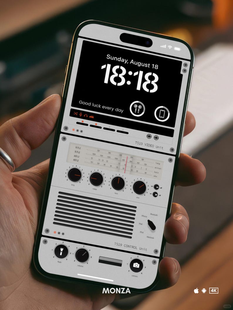 May include: A smartphone mockup with a custom interface showing a digital clock displaying "18:18" and the text "Sunday, August 18". The screen also shows the text "Good luck every day" and the words "TS19 VIDEO Unit" and "TS19 CONTROL Unit". The phone is labeled "MONZA" at the bottom.