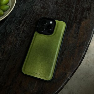 May include: A smartphone case with a textured olive green back panel and a black frame. The case features a triple-lens camera cutout at the top and the word bluestone printed in small black letters near the bottom edge of the green surface.