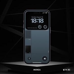 May include: A black smartphone with a gray screen displaying the time 18:18 and the date Sunday, August 18. The text "Good luck every day" is displayed below the time. The phone is on a black surface with the word "MONZA" written below it.