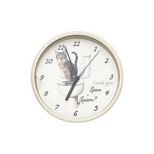 May include: A white round clock with black hands and black numbers. A cat is sitting on a toilet with the text "Could you Spare a Square?" printed on the clock face.