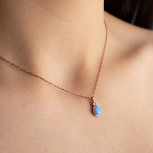 Puede incluir: Un delicado collar de cadena de oro rosa con un colgante en forma de l&aacute;grima que presenta una &oacute;palo azul claro y dos peque&ntilde;os diamantes.