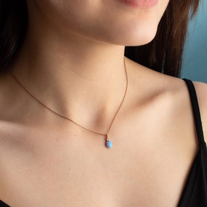 Puede incluir: Un delicado collar de cadena de oro rosa con un colgante de &oacute;palo en forma de l&aacute;grima.