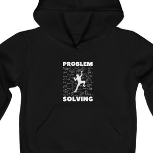 Op de afbeelding: Zwarte hoodie met een kangoeroezak. De voorkant toont de woorden "PROBLEM SOLVING" boven en onder een witte afbeelding van een klimmende persoon, met wiskundige vergelijkingen op de achtergrond. Ontworpen voor casual wear.