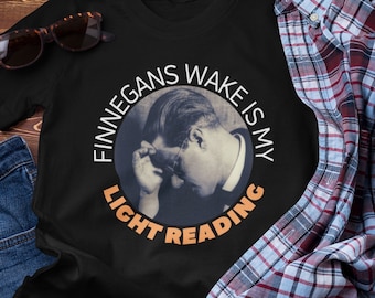 May include: Black t-shirt with a circular graphic featuring a man's face and the text "Finnegans Wake is my light reading".
