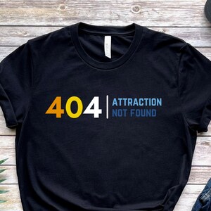 Pode incluir: Camiseta preta com um design gráfico que diz "404 Attraction Not Found".