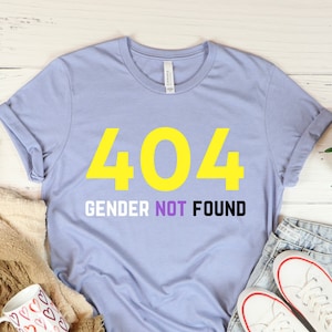 May include: Light blue t-shirt with a yellow 404 and the text "Gender Not Found" in black.