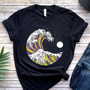 Puede incluir: Camiseta negra con un gráfico de una ola morada y amarilla con una luna blanca en el fondo.
