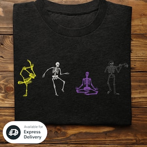 May include: A black t-shirt with four skeletons in different poses. The skeletons are white, yellow, purple, and gray. The skeletons are doing yoga poses. The t-shirt is available for express delivery.