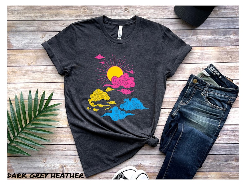 May include: A dark grey heather t-shirt with a graphic of a sun and clouds in pink, yellow, and blue colors. The graphic is a representation of the pansexual pride flag.