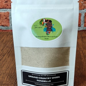 May include: A white resealable pouch with a black label that reads "103% PURE GROUND COUNTRY ONION RONDELLE NO ARTIFICAL COLOURS OR ADDITIVES". The pouch contains a light brown powder.