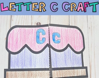 Puede incluir: Una actividad artesanal para aprender la letra C. La artesanía está hecha de papel y es de color rosa, morado y marrón. La letra C está escrita en azul en la artesanía.
